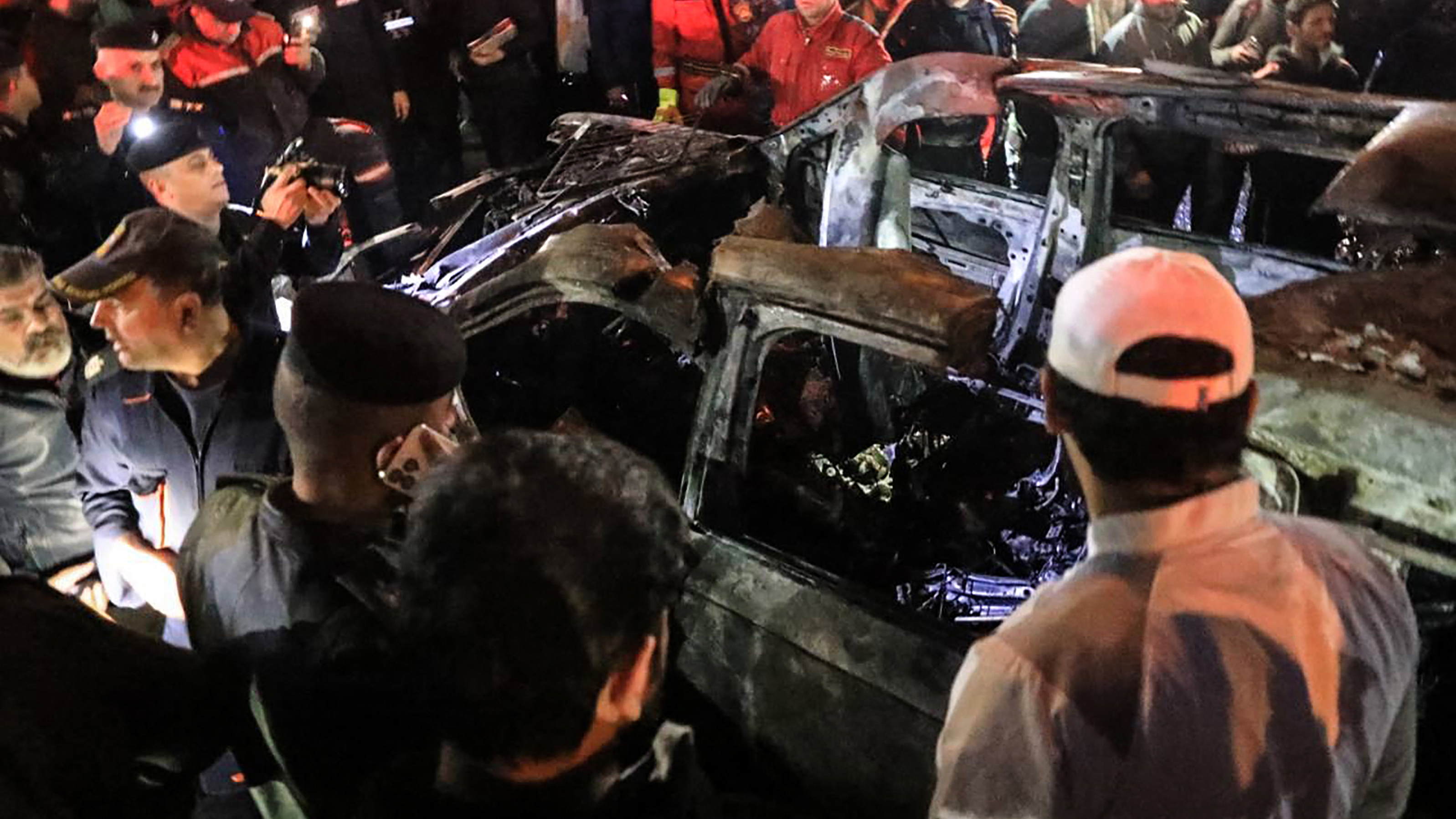 People, rescuers and security forces gather around a vehicle hit by a drone strike, reportedly killing three people, including two leaders of a pro-Iran group, in Baghdad on Wednesday.